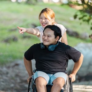 Two friends share a joyful moment outdoors, highlighting friendship and inclusivity.