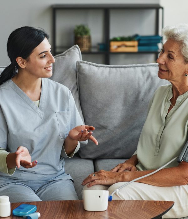 Young Nurse Talking to Senior Woman in Retirement Home